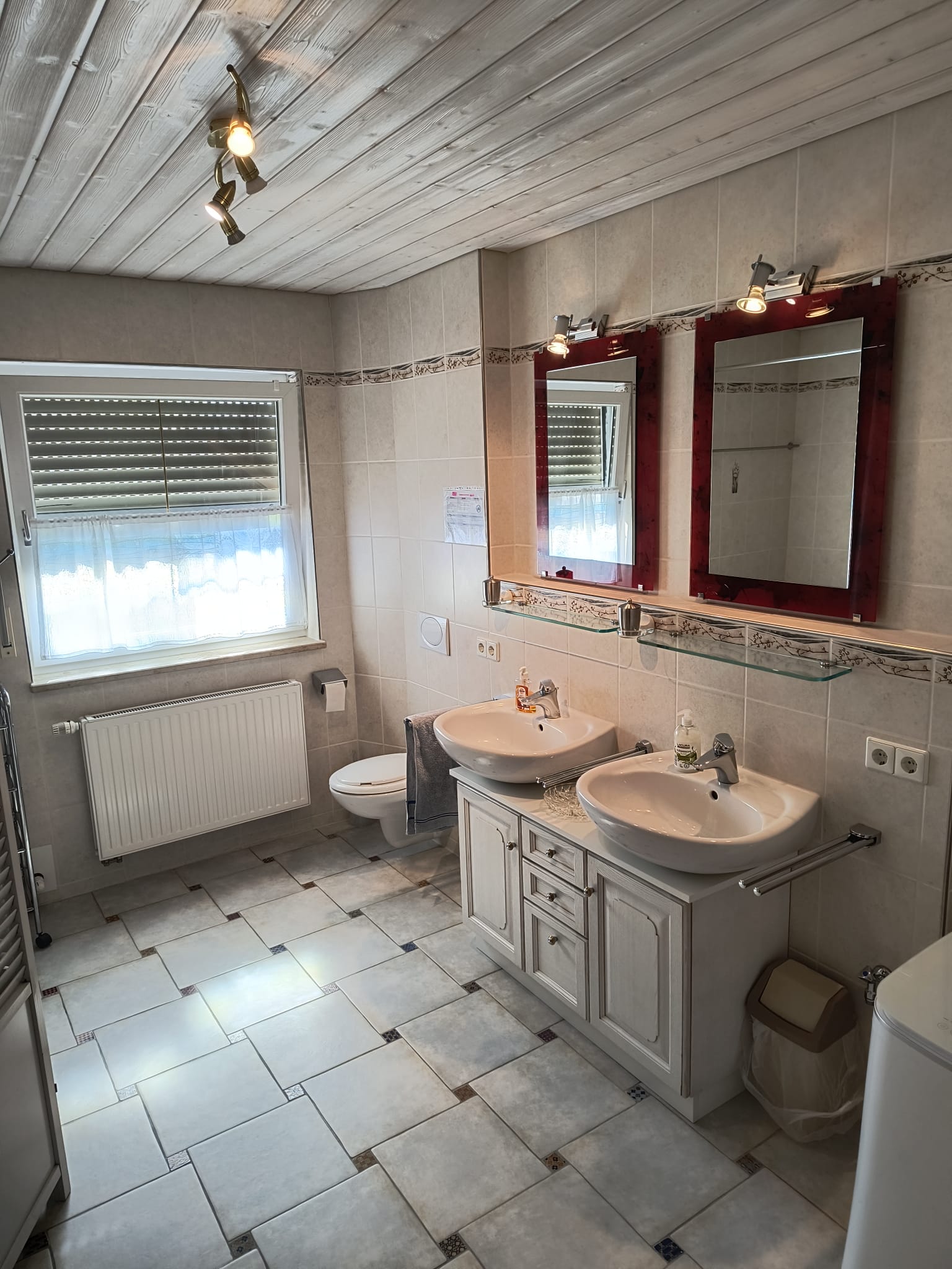 Badezimmer mit zwei Waschbecken, Dusche, Tageslicht, WC, Spiegel, Abstellflächen, Waschmaschine, Fußbodenheizung